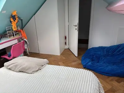 a bedroom with a bed and a desk and a door at Stay in maison de metre in Etterbeek in Brussels