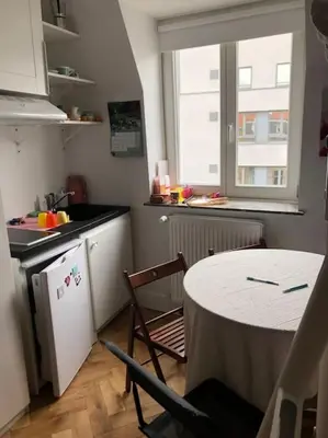 a kitchen with a table and a kitchen with a table and chairs at Stay in maison de metre in Etterbeek in Brussels