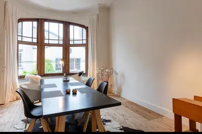a dining room with a table and a large window at Bohemian city loft in Ghent