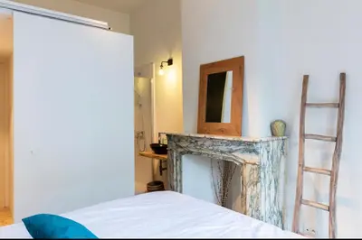 a room with a fireplace with a mirror and a ladder at Bohemian city loft in Ghent