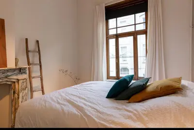 a bedroom with a bed with pillows and a window at Bohemian city loft in Ghent
