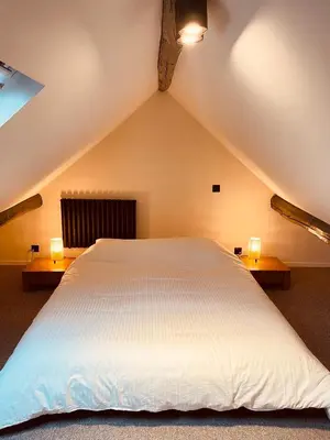 a large white bed in a attic with two lights at Camus Flats in Brussels