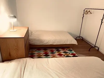 a room with two beds and a table with a lamp at Camus Flats in Brussels