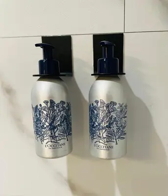 two bottles of soap are sitting on a wall at Camus Flats in Brussels