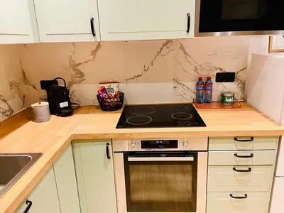 a kitchen with white cabinets and a stove top oven at Camus Flats in Brussels