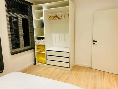 a bedroom with a closet with a bed and a window at Camus Flats in Brussels