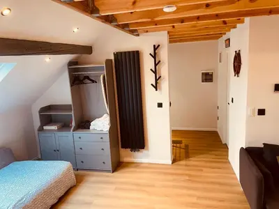 a bedroom with a bed and a dresser in a room at Camus Flats in Brussels