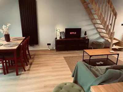 a living room with a couch and a table with a tv at Camus Flats in Brussels