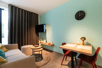 a living room with a couch and a table at SYBA Gastenverblijf in Evergem