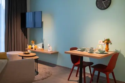a living room with a table and chairs and a couch at SYBA Gastenverblijf in Evergem