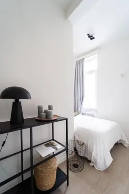 a bedroom with a bed and a table with a lamp at Urban Cityflats - Center Antwerp in Antwerp