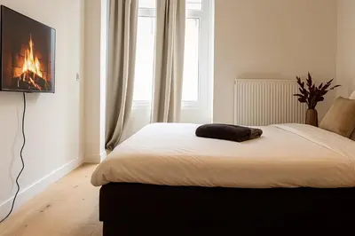 a bedroom with a bed with a fireplace in it at SLEEP INN - Palace Apartments - 2 Bedrooms in Antwerp