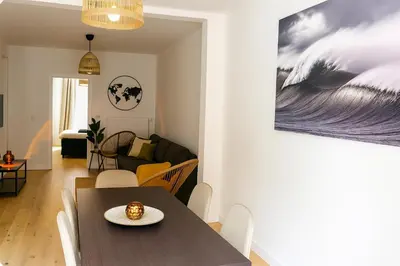a dining room and living room with a table and chairs at SLEEP INN - Palace Apartments - 2 Bedrooms in Antwerp