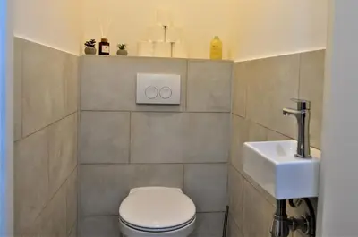 a bathroom with a toilet and a sink at SLEEP INN - Palace Apartments - 2 Bedrooms in Antwerp