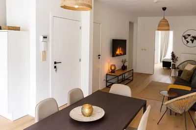 a dining room and living room with a table and chairs at SLEEP INN - Palace Apartments - 2 Bedrooms in Antwerp