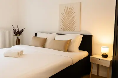 a bedroom with a bed with white sheets and pillows at SLEEP INN - Palace Apartments - 2 Bedrooms in Antwerp