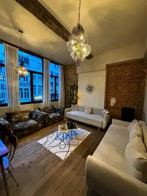 a living room with couches and a chandelier at LouLou Home's in Antwerp