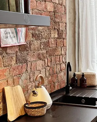 a kitchen counter with a tea kettle and a brick wall at LouLou Home's in Antwerp