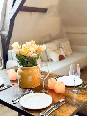 a table with plates and glasses and a vase of flowers at LouLou Home's in Antwerp