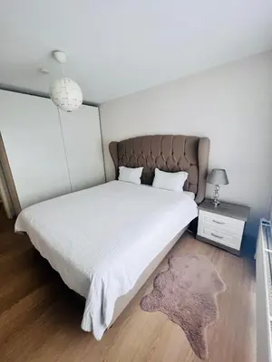 a bedroom with a large white bed with a brown headboard at Windsor Residence Grimbergen in Grimbergen