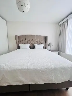 a bedroom with a large bed with a white comforter at Windsor Residence Grimbergen in Grimbergen