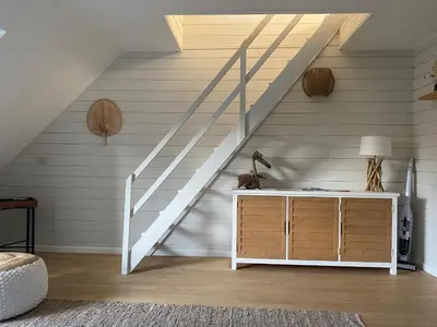 a staircase in a room with a dresser and a stair case at Cottage en bordure bruxelloise in Wezembeek-Oppem