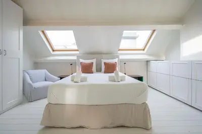 a bedroom with a large white bed with skylights at SHWAY - The Handshake House in Antwerp