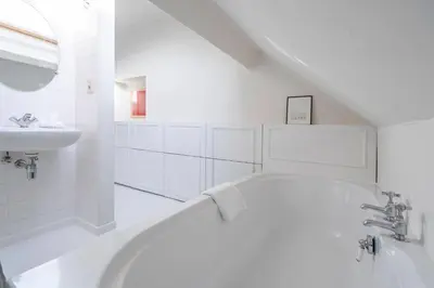 a white bathroom with a tub and a sink at SHWAY - The Handshake House in Antwerp