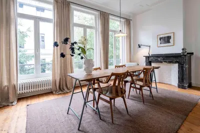 a dining room with a table and chairs and a fireplace at SHWAY - The Handshake House in Antwerp