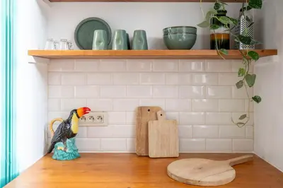 a toy bird sitting on a wooden floor in a kitchen at SHWAY - The Handshake House in Antwerp