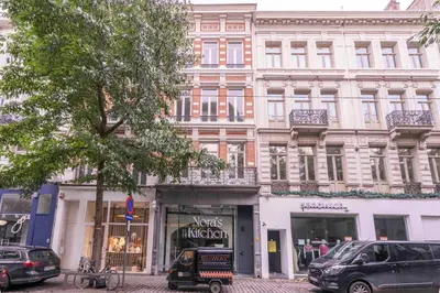 a large white building with a store on a street at SHWAY - The Handshake House in Antwerp
