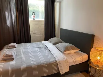 a bed in a bedroom with a window and a lamp at Rustiek vakantiehuis in 't groen in Lier