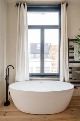 a large white bath tub in front of a window at Gezellig gerenoveerd herenhuis in het centrum in Antwerp
