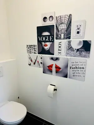 a bathroom with a toilet and pictures on the wall at Urbanstay Suites Grand Place Luxury Apartment in Brussels