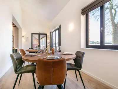 a dining room with a wooden table and chairs at Lindehoeve in Turnhout