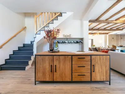 a living room with a wooden cabinet and stairs at Lindehoeve in Turnhout