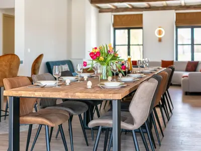 a large wooden table with chairs and flowers on it at Lindehoeve in Turnhout