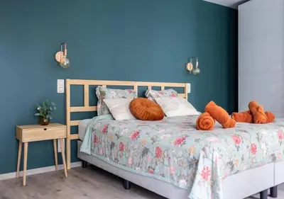 two beds in a bedroom with a blue wall at Cozy 3BR Home near Meir in Antwerp City Centre in Antwerp