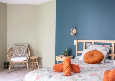 a bedroom with a bed with a blue wall at Cozy 3BR Home near Meir in Antwerp City Centre in Antwerp