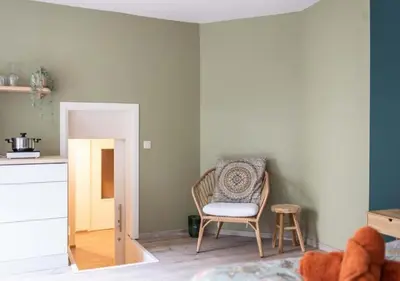 a living room with a chair and a table at Cozy 3BR Home near Meir in Antwerp City Centre in Antwerp