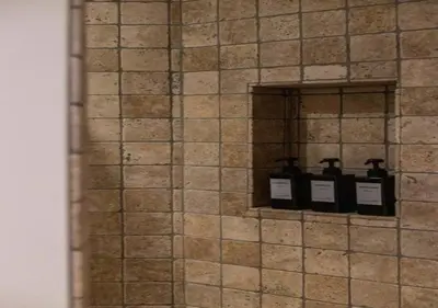 a row of three bottles on a tiled wall at Cozy 3BR Home near Meir in Antwerp City Centre in Antwerp