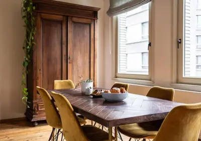 a dining room with a wooden table and chairs at Cozy 3BR Home near Meir in Antwerp City Centre in Antwerp