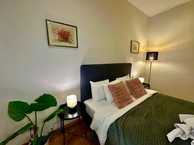 a bedroom with a bed with pillows and a plant at Luxury Suites Museum by Rikas Hotels in Antwerp