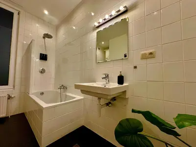a bathroom with a sink and a mirror at Luxury Suites Museum by Rikas Hotels in Antwerp