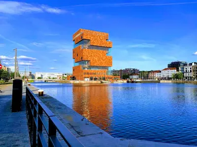 a tall building next to a body of water at The Wonder Shore in Antwerp