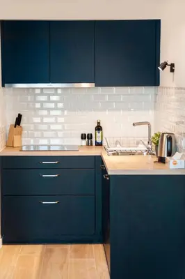 a kitchen with blue cabinets and a sink at The Wonder Shore in Antwerp