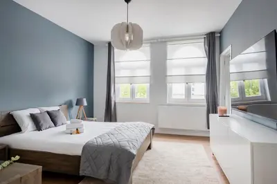 a bedroom with blue walls and a bed and a sink at Evere EU Residence in Brussels