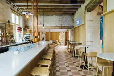 a restaurant with a bar with tables and chairs at Hopspot in Evergem