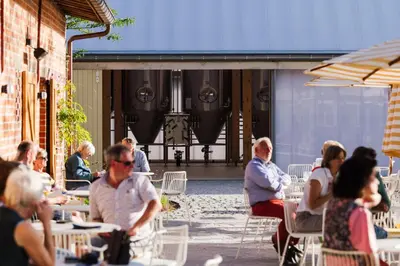 a group of people sitting at tables in a patio at Hopspot in Evergem