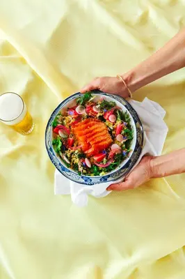 a person holding a plate of food with a salad at Hopspot in Evergem